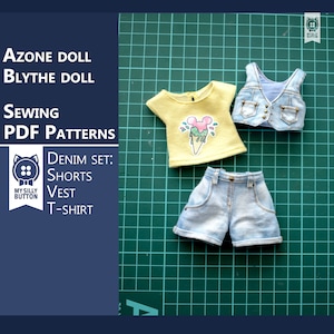 Może przedstawiać: Zestaw odzieży dżinsowej dla lalek Azon lub Blythe. Zestaw zawiera kamizelkę, spodenki i żółtą koszulkę z grafiką lodów. Ubrania są rozłożone na zielonej macie do cięcia.