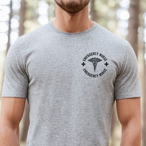May include: A gray t-shirt with a black graphic of a medical symbol and the text "EMERGENCY NURSE" around it.