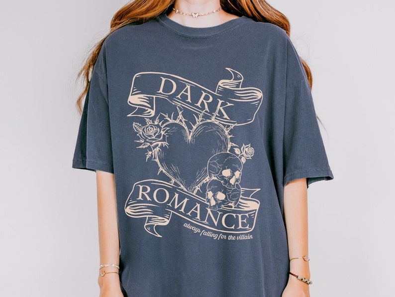 Op de afbeelding: Een donkerblauw oversized T-shirt met een grafische print van een hart met doornen, schedels en een banner met de tekst "DARK ROMANCE always falling for the villain".