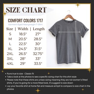 May include: Size chart for a garment-dyed heavyweight t-shirt. The chart shows the width and length measurements in inches for sizes S through 4XL. The chart also includes a photo of a grey t-shirt.