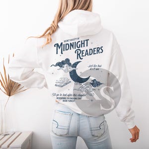 Pu&ograve; includere: Felpa con cappuccio bianca con la scritta blu navy "SECRET SOCIETY OF MIDNIGHT READERS". Il design include una luna crescente, nuvole e un libro aperto. Sono inclusi anche i testi "just like that it's 2 am" e "I'll go to bed after this chapter, nevermind, I'm finishing this book tonight".