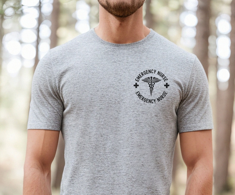 May include: A gray t-shirt with a black graphic of a medical symbol and the text "EMERGENCY NURSE" around it.