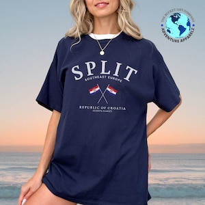Może przedstawiać: Uniseksowa koszulka w kolorze granatowym z białym napisem "SPLIT SOUTHEAST EUROPE" i grafiką dwóch skrzyżowanych chorwackich flag. Pod flagami znajduje się napis "REPUBLIC OF CROATIA 43.5007N, 16.4402E".