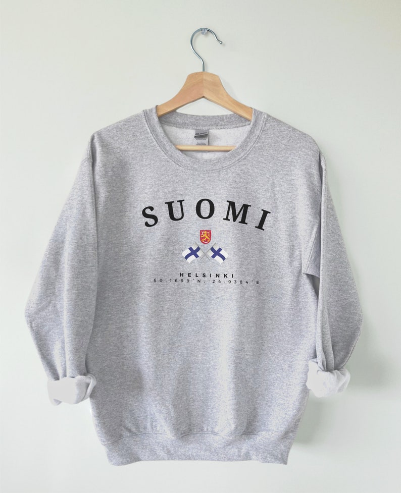 以下が含まれることがあります： グレーのトレーナーに、黒い文字で「SUOMI」と書いてあり、フィンランドの国旗が2つ交差して、黒い文字で「HELSINKI 60.1699&deg; N, 24.9384&deg; E」と書いてあります。