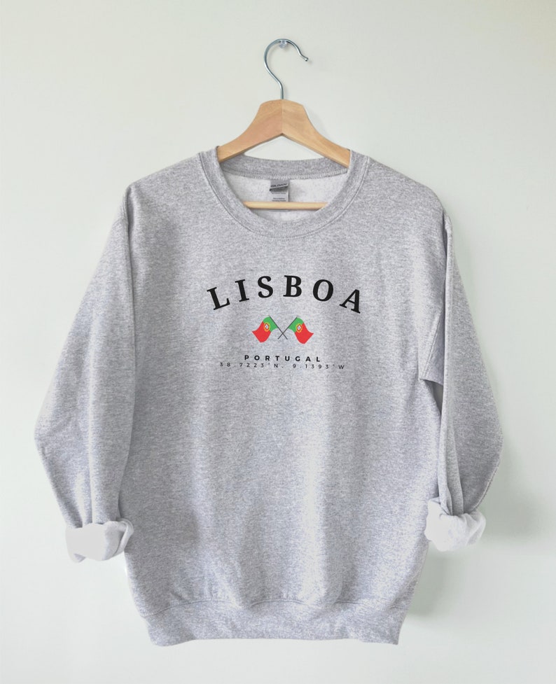 May include: Grey sweatshirt with the text "LISBOA" in black, two crossed Portuguese flags, and the text "PORTUGAL 38.7223&deg;N 9.1393&deg;W" in black.