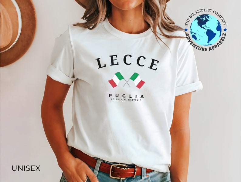 May include: White unisex t-shirt with the word "LECCE" in black, and two crossed Italian flags. Below, "PUGLIA" is printed, along with coordinates. The Bucket List Company logo is on the upper right.