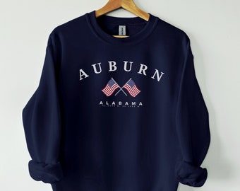 May include: Navy blue sweatshirt with white text that reads "AUBURN" and "ALABAMA" with two crossed American flags.