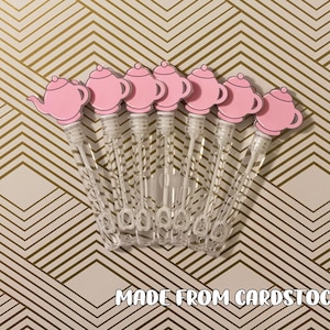May include: Seven pink teapot shaped bubble wands with clear plastic handles.  The text "MADE FROM CARDSTOCK" is printed below the wands.