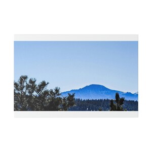 Puede incluir: Una vista panorámica de una cordillera con un cielo azul y algunos árboles en primer plano.