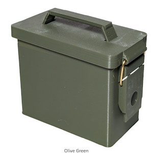 Può includere: Una scatola portaoggetti rettangolare verde oliva con coperchio incernierato e maniglia sulla parte superiore. La scatola ha una chiusura in metallo e un piccolo foro rotondo sul lato. Il testo "Olive Green" è in basso nell'immagine.