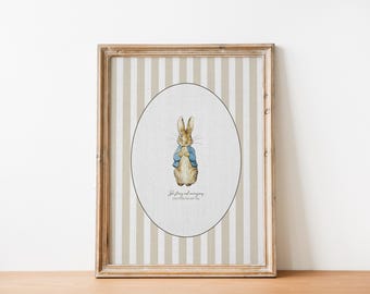 May include: Framed print featuring a watercolor illustration of a rabbit in a blue jacket. The artwork is set within an oval on a striped background, framed in a wooden frame. The text at the bottom reads "Be stirring and courageous".