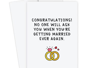 May include: A white card with black text that reads "Congratulations! No one will ask you when you're getting married ever again."  The card has a simple illustration of two gold rings with a red heart on top.