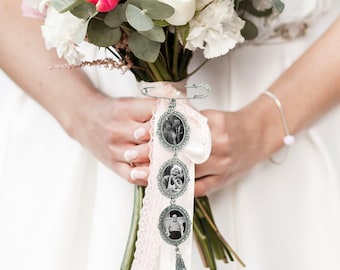 May include: A bridal bouquet charm featuring three oval photo frames, each displaying a black and white photograph of a couple. The charm is attached to a white satin ribbon with a pink lace trim and a tassel.