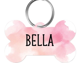 May include: Pink watercolor bone-shaped dog tag with a silver ring and the name "BELLA" printed in black.