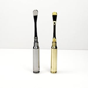 Pode incluir: Duas ferramentas feitas de estojos de munição reutilizados. Uma ferramenta é prateada com uma alça preta e a outra é dourada com uma alça de latão.