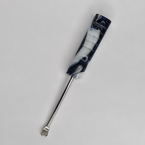 Puede incluir: Una herramienta con un mango veteado azul y blanco y una cuchara de metal plateado en el extremo. La herramienta está en ángulo diagonalmente contra un fondo blanco. El mango tiene una apariencia texturizada.