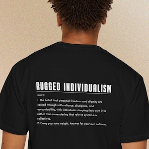 Könnte beinhalten: Schwarzes T-Shirt mit der weißen Definition von "RUGGED INDIVIDUALISM". Die Definition beinhaltet das Nomen, den Glauben an persönliche Freiheit und Würde sowie die Bedeutung von Selbstständigkeit und Verantwortlichkeit. Das Design ist schlicht.