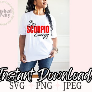 May include: A white t-shirt with the text "Big Scorpio Energy" in black and red lettering. The text is in a bold, stylized font. The shirt is being worn by a person with dark hair.