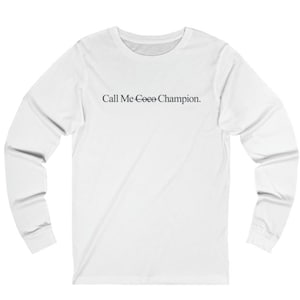 May include: White long-sleeve t-shirt with the text "Call Me Coco Champion." printed on the front.