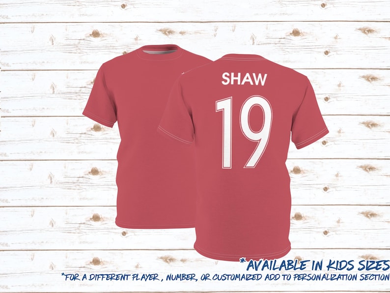 May include: Red soccer jersey with white text and number "SHAW 19". Available in kids sizes.