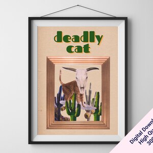 Könnte beinhalten: Gerahmter Kunstdruck mit einer braunen Katze, die einen Kuhschädel trägt und zwischen Kakteen skateboardet. Die Worte "deadly cat" sind in Grün und Orange gehalten. Der Druck ist in einem schwarzen Rahmen.