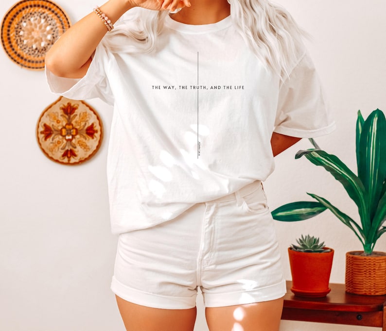 May include: White t-shirt with the text "The way, the truth, and the life" and a vertical line down the centre. The text "John 14:6" is at the bottom of the line.