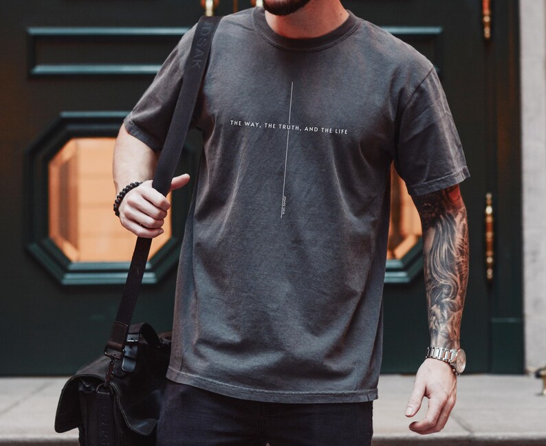 May include: A dark grey t-shirt with the text "The way, the truth, and the life" printed on the front.