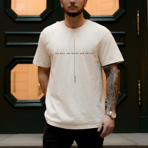 May include: A white t-shirt with the text "THE WAY, THE TRUTH, AND THE LIFE" printed on the front. The text is centred and aligned vertically.