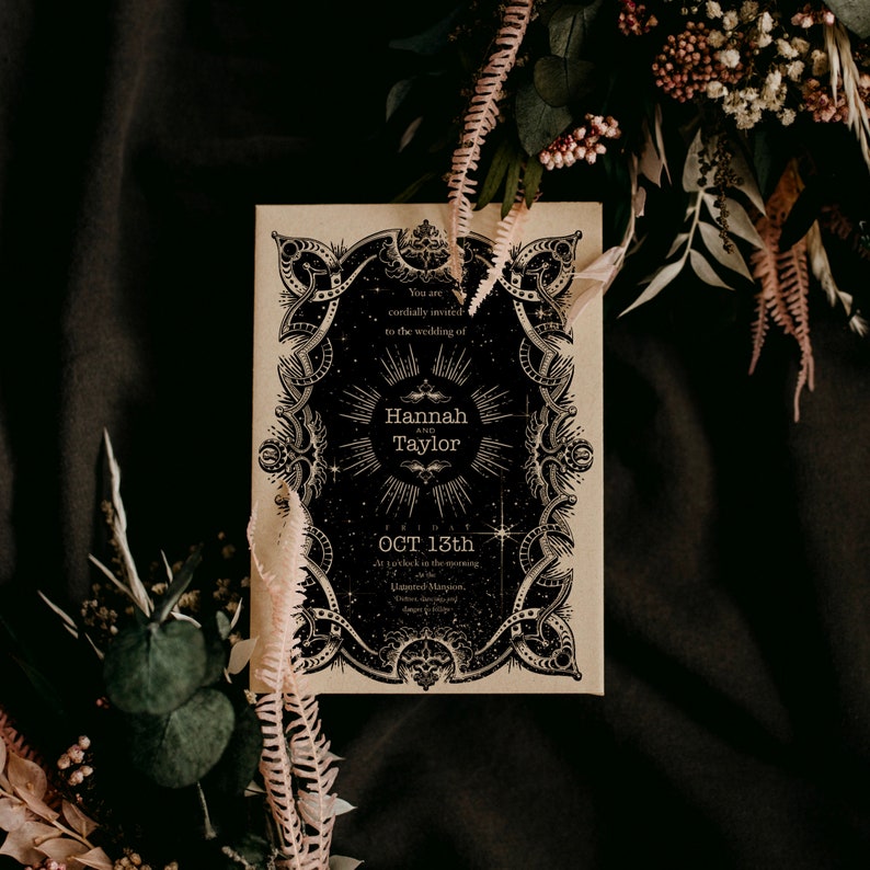 Puede incluir: Una invitaci&oacute;n de boda de estilo vintage con elementos de dise&ntilde;o celestiales en blanco y negro. La invitaci&oacute;n presenta los nombres "Hannah y Taylor" y la fecha "OCT 13th". La invitaci&oacute;n est&aacute; rodeada de flores secas y vegetaci&oacute;n.