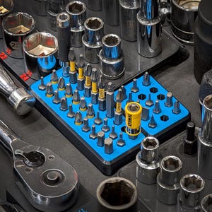 May include: A blue and yellow tool organizer with a variety of screwdriver bits and a magnetic bit holder. The organizer is filled with different sizes of screwdriver bits, all neatly arranged in rows. The organizer is made of plastic and has a blue base with yellow accents.