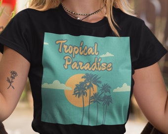 May include: Black t-shirt with a "Tropical Paradise" design. The graphic features a sunset, palm trees, and clouds in orange, teal, and cream. The text "Tropical Paradise" is in a retro font.