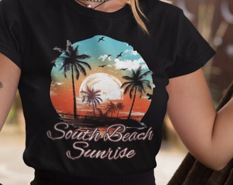 Può includere: Maglietta nera con una grafica di un tramonto su palme e il testo "South Beach Sunrise".