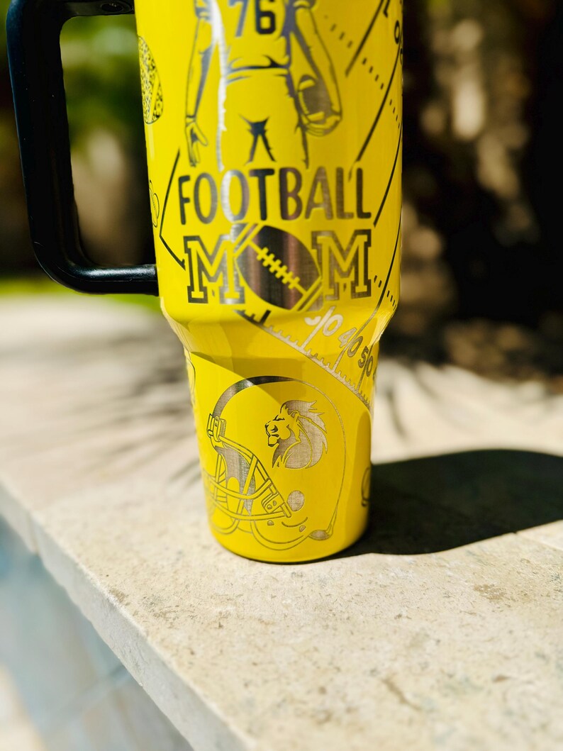 May include: Yellow stainless steel tumbler with a football player, a football helmet, and the text "FOOTBALL MOM".
