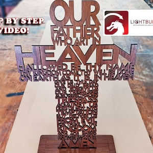 May include: A wooden cross-shaped art piece with the Lord's Prayer cut out in the wood. The words "Our Father" and "Heaven" are prominently displayed. The Lightburn logo is in the upper right corner. The words "Step by Step Video!" are in the upper left.