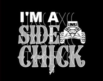 May include: White graphic text on a black background that reads "I'm a Side By Side Chick". A white silhouette of a side-by-side vehicle is centered above the text.
