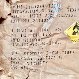 May include: A brown paper bag with the text "POTASSIUM NITRATE TECH" and "LOT NO 21080". The bag also has a yellow warning label with the text "OXIDIZER".
