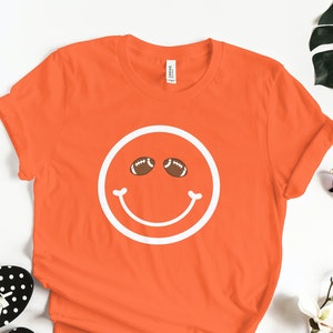 Smiley Face Football Eyes t-shirt Sports Mom Graphic T Friday Night Lights Football Shirt Design