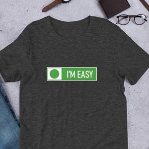 May include: A dark heather grey t-shirt with a green circle and the text "I'M EASY" in white.