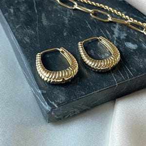 Könnte beinhalten: Rustikales Holzschild mit dem Text "Welcome to our home" in weißen Buchstaben. Das Schild hat eine Used-Optik und ein schlichtes, einladendes Design, ideal für die Dekoration der Haustür.