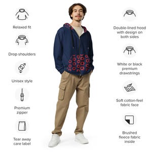 May include: A navy blue zip-up hoodie with a red circular pattern on the pockets and hood lining. The hoodie features a double-lined hood, drop shoulders, and a premium zipper. The pants are khaki-coloured cargo pants. The hoodie is unisex.