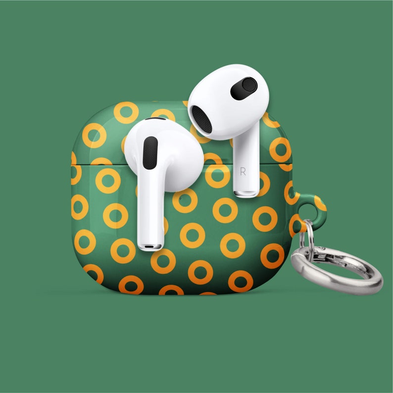 Peut inclure: Un &eacute;tui blanc pour Airpods avec un motif de beignets vert et jaune. L'&eacute;tui est dot&eacute; d'un anneau argent&eacute;.