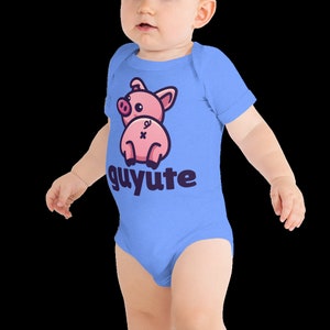 Puede incluir: Un body de bebé azul claro con un cerdo rosa de dibujos animados que lleva un lazo rosa y el texto "guyute" en azul oscuro.