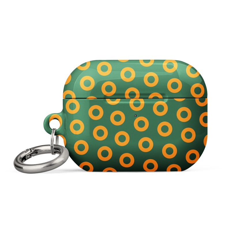 Peut inclure: Un &eacute;tui pour Airpods vert et orange avec un motif de beignets et un porte-cl&eacute;s argent&eacute;.