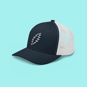 May include: A navy blue trucker hat with a white mesh back and a curved brim. The hat features a white embroidered design on the front. The hat is set against a light blue background.