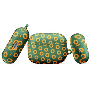 Peut inclure: Une coque pour Airpods verte et orange avec un motif r&eacute;p&eacute;titif de cercles orange sur fond vert.