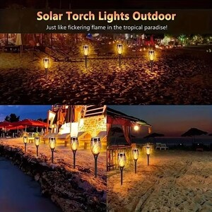 May include: Solar powered torch lights with a flickering flame effect. The lights are placed on a sandy beach at night, creating a warm and inviting atmosphere.  "Solar Torch Lights Outdoor" and "Just like flickering flame in the tropical paradise!" are written in the image.
