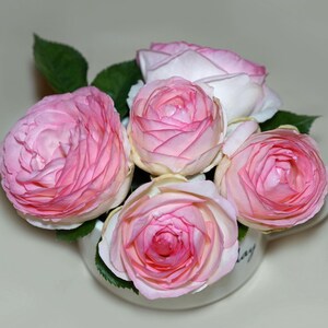 Peut inclure: Un bouquet de cinq roses roses dans une tasse en c&eacute;ramique blanche. Les roses sont dispos&eacute;es en cercle, les tiges vers l'ext&eacute;rieur. La tasse a un design simple et est d&eacute;cor&eacute;e du mot "aujourd'hui" sur le c&ocirc;t&eacute;.