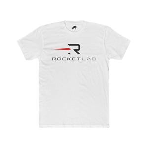May include: White t-shirt with the Rocket Lab logo in black and red. The logo features a stylized letter "R" with a red horizontal line extending to the left, and the text "ROCKETLAB" below.