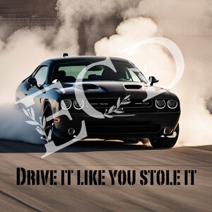 May include: A black Dodge Challenger sports car with smoke coming from the tires as it drifts on a race track. The car has a black grill and headlights, and the text "DRIVE IT LIKE YOU STOLE IT" is printed on the track.