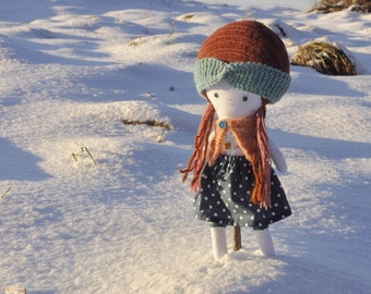 Dressed cloth rag doll of original design, with sweater, skirt and knitted headband